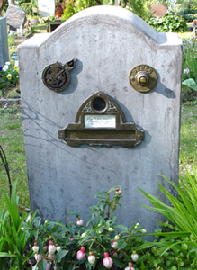 Ein Grab mit Klingel und Briefkasten mit Briefklappe